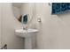 Powder room features a white pedestal sink, rounded mirror, and stylish lighting at 3600 Plainview Dr, Orlando, FL 32824