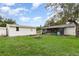 A view of the backyard of the home with green grass, firepit, shed, and screened in porch at 407 Ventura Dr, Sanford, FL 32773