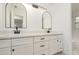 Bathroom with double vanity featuring white cabinetry, white countertop, black hardware, and dual arched mirrors at 407 Ventura Dr, Sanford, FL 32773