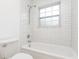 All-white bathroom features subway tile, a shower/tub combination, and modern fixtures at 407 Ventura Dr, Sanford, FL 32773