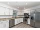 Well-lit kitchen with granite countertops, stainless appliances, and white cabinetry for a modern look at 407 Ventura Dr, Sanford, FL 32773