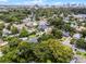 Aerial view showcases a vibrant neighborhood with lush trees and a distant cityscape skyline in the background at 424 E Muriel St, Orlando, FL 32806