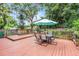 Wooden back deck perfect for outdoor entertaining with an umbrella-covered dining table and chairs at 424 E Muriel St, Orlando, FL 32806