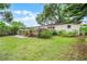 Backyard featuring a wooden deck, a grassy lawn, mature trees, and privacy fencing at 424 E Muriel St, Orlando, FL 32806
