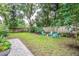 A lush backyard featuring a grassy lawn and three chairs positioned around a fire pit at 424 E Muriel St, Orlando, FL 32806