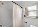 Simple, bright bathroom featuring white subway tiles in shower and a shower curtain and window at 424 E Muriel St, Orlando, FL 32806