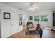Cozy bedroom with a sitting area, neutral walls, hardwood floors, and a white ceiling fan and updated white trim at 424 E Muriel St, Orlando, FL 32806