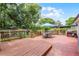 Spacious wooden deck features an outdoor dining set, trees, and a backyard at 424 E Muriel St, Orlando, FL 32806