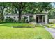 Charming single-story home with lush front yard, mature trees, and covered carport at 424 E Muriel St, Orlando, FL 32806