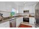Modern kitchen with white cabinetry, stainless steel appliances, and granite countertops at 424 E Muriel St, Orlando, FL 32806