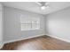 Cozy bedroom featuring a ceiling fan, a window, and laminate wood flooring at 5126 Saint Charles Ln # 43, Orlando, FL 32822