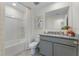 Stylish bathroom features gray vanity with granite countertop, tub/shower combo with white surround and ample lighting at 6006 Galloping Dr, Apopka, FL 32712