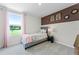 Bright bedroom featuring a gray bed frame, accent wall, and large window with a view at 6006 Galloping Dr, Apopka, FL 32712