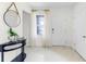 Bright entryway with neutral walls, tile floors, a decorative table, and a view through sheer curtains at 6006 Galloping Dr, Apopka, FL 32712
