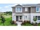 Charming two-story townhome featuring a covered entry and stone accents, creating an inviting curb appeal at 6006 Galloping Dr, Apopka, FL 32712