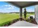 Covered patio featuring decorative columns, landscaping, and a view of the spacious green lawn at 6006 Galloping Dr, Apopka, FL 32712
