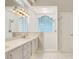 Bathroom featuring a double sink vanity, walk-in shower, white tile, and glass block window for natural light at 6609 Crenshaw Drive, Orlando, FL 32835