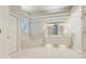 Bright bathroom featuring double vanity, a soaking tub, tiled floor, and glass block window for privacy at 6609 Crenshaw Drive, Orlando, FL 32835