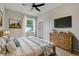 Stylishly staged bedroom featuring wood dresser, lamp, painting, and TV at 6609 Crenshaw Drive, Orlando, FL 32835
