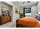Bedroom featuring wood floors, dresser, art, and bright window at 6609 Crenshaw Drive, Orlando, FL 32835