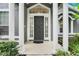Elegant front entrance with a stylish black door, flanked by white columns and sidelights at 6609 Crenshaw Drive, Orlando, FL 32835