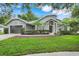 Charming single-story home featuring a lush front yard and elegant architectural details at 6609 Crenshaw Drive, Orlando, FL 32835