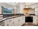 Kitchen featuring stainless steel appliances, black countertops, white cabinets, and a stylish backsplash at 6609 Crenshaw Drive, Orlando, FL 32835