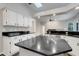 Bright kitchen featuring white cabinetry, black countertops, and a large center island at 6609 Crenshaw Drive, Orlando, FL 32835