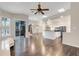 Open living room, connected to kitchen, featuring hardwood floors and sliding door access to the pool area at 6609 Crenshaw Drive, Orlando, FL 32835