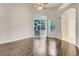 Well-lit living room with wood-look tile flooring, large windows, and a sliding glass door to the pool at 6609 Crenshaw Drive, Orlando, FL 32835