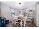 Bright dining room with a modern light fixture, a wood-topped table with white chairs, and stylish decor at 824 Timor Ave, Orlando, FL 32804