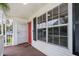 Inviting front porch with wood flooring, featuring a red front door and a charming window providing ample natural light at 824 Timor Ave, Orlando, FL 32804