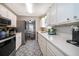Bright kitchen features white cabinetry, stainless steel appliances, and charming patterned flooring at 824 Timor Ave, Orlando, FL 32804