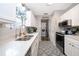 Modern kitchen featuring white cabinetry, stainless steel appliances, eye-catching tile flooring, and a laundry area at 824 Timor Ave, Orlando, FL 32804