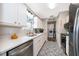 Bright kitchen with white cabinets, stainless steel appliances, mosaic tile flooring, and a convenient laundry area at 824 Timor Ave, Orlando, FL 32804