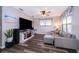 Cozy living room with a large television, comfortable gray sofa, ceiling fan, and stylish dark wood-look flooring at 824 Timor Ave, Orlando, FL 32804