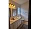 This bathroom features a double sink vanity, a window for natural light, and tiled floors at 8718 Fort Shea Ave, Orlando, FL 32822