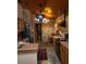 This kitchen showcases wood cabinets, brick accent wall, a hanging pot rack, and stone tile flooring at 8718 Fort Shea Ave, Orlando, FL 32822
