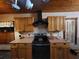 This kitchen features wood cabinets, a black range hood, and tiled backsplash at 8718 Fort Shea Ave, Orlando, FL 32822