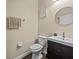 Clean half bathroom featuring modern fixtures, a dark vanity, and neutral wall color at 9034 Paolos Place Paolos Place, Kissimmee, FL 34747