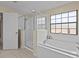 Bright bathroom with a soaking tub, a glass-door shower, and a large window at 9034 Paolos Place Paolos Place, Kissimmee, FL 34747