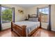 Bedroom features a wood bed frame and views from two windows at 9034 Paolos Place Paolos Place, Kissimmee, FL 34747