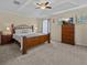Comfortable bedroom with a tray ceiling, ceiling fan, a bed, and an entertainment center at 9034 Paolos Place Paolos Place, Kissimmee, FL 34747