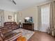 Comfortable living room featuring a leather sofa, ceiling fan, and large screen TV at 9034 Paolos Place Paolos Place, Kissimmee, FL 34747