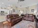 Inviting living room featuring two leather sofas, tile flooring, and ceiling fan at 9034 Paolos Place Paolos Place, Kissimmee, FL 34747