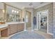 Elegant bathroom with floral wallpaper, large mirror, vanity, and walk-in closet featuring ample storage space at 922 N Pennsylvania Ave, Winter Park, FL 32789