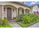 Inviting covered front porch with stone columns, wooden front door, and manicured landscaping at 922 N Pennsylvania Ave, Winter Park, FL 32789