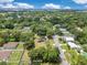 An aerial view displays a home nestled among lush trees in a verdant neighborhood at 9329 7Th Ave, Orlando, FL 32824