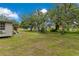 Large grassy backyard with mature trees providing ample space for outdoor activities at 9329 7Th Ave, Orlando, FL 32824