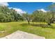 Expansive backyard features lush green grass and mature shade trees, perfect for outdoor activities at 9329 7Th Ave, Orlando, FL 32824